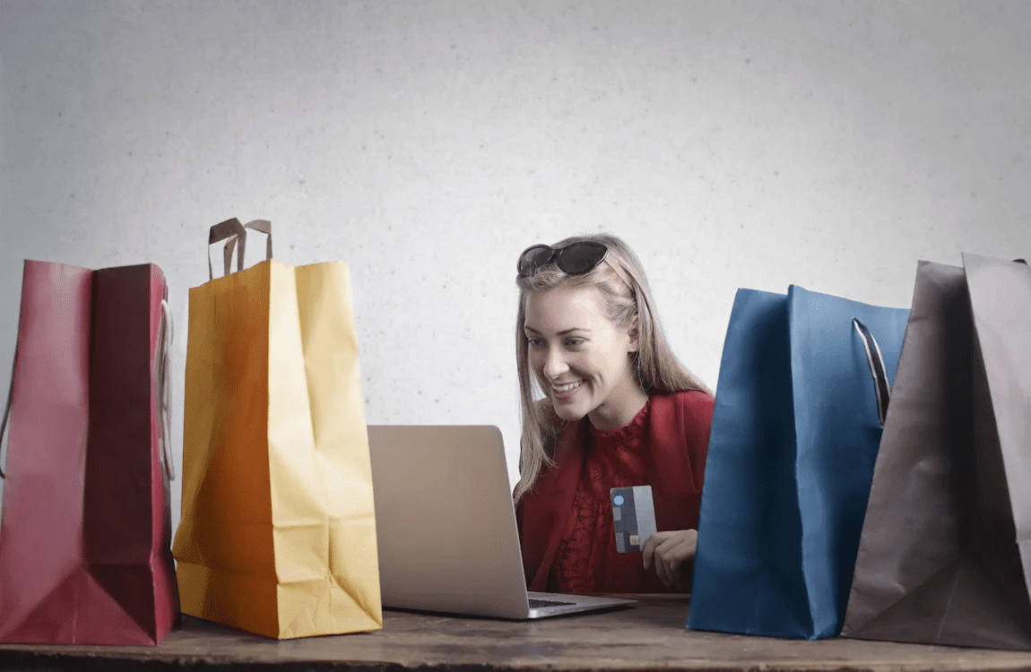  woman looking at laptop and holding credit card