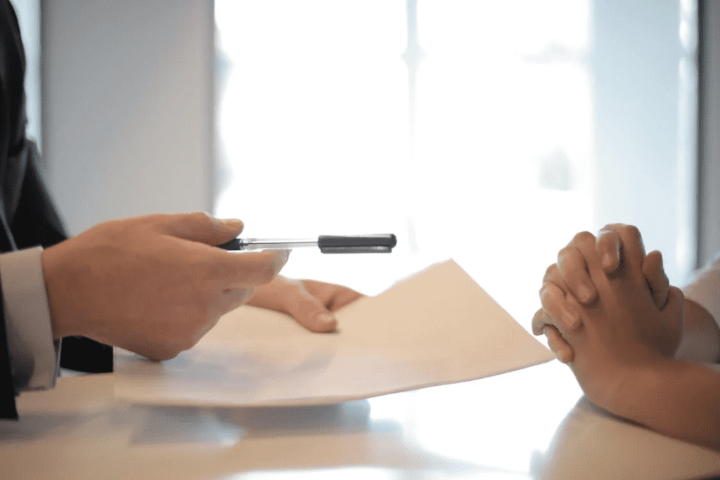 businessman giving contract to woman to sign
