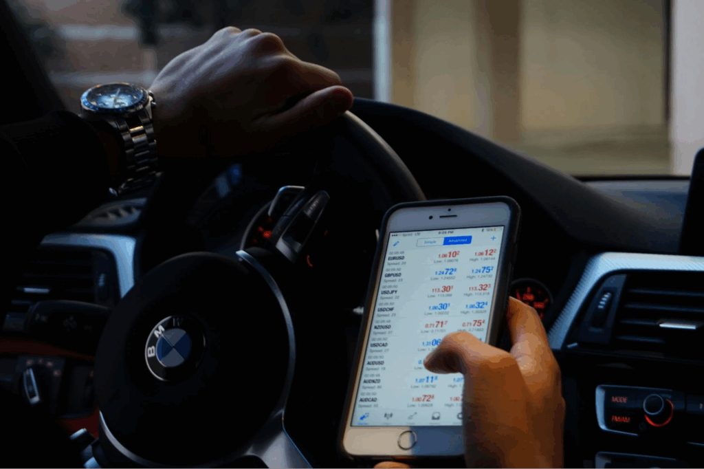 unseen man holding phone checking trading data