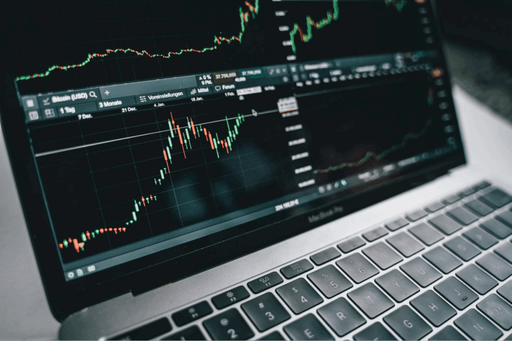  black and silver laptop with stock market display on screen